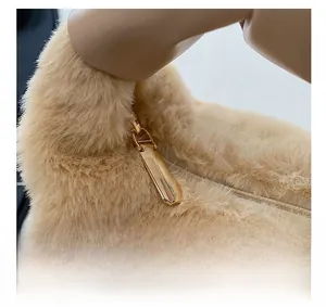 Détail de la fermeture éclair en métal doré lisse sur un sac à main en peluche beige doux
