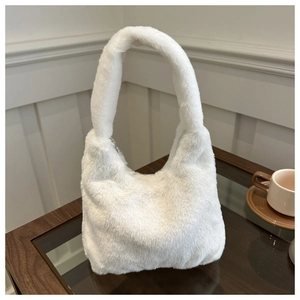 Detail of soft white faux fur tote bag showing plush texture on a cozy wooden table