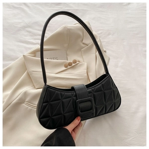 Détail d'un sac sous le bras en cuir noir avec surpiqûres triangles et boucle