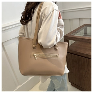 Dettaglio della borsa tote in pelle beige con tasca funzionale con cerniera frontale