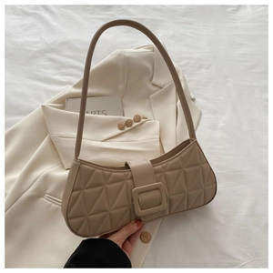 Détail du sac sous le bras matelassé géométrique kaki avec boucle carrée sur fond blanc
