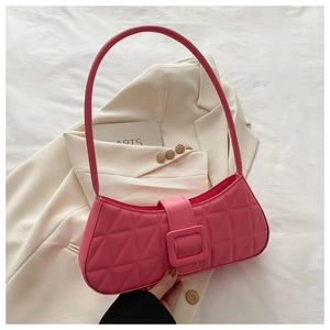 Détail d'un sac sous le bras rose matelassé avec une grande boucle carrée décorative