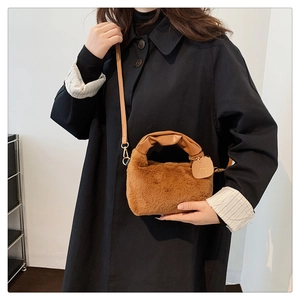 Détail d'un sac à main en peluche marron avec fausse fourrure et poignée en cuir PU plissé