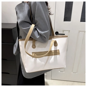 Grande borsa tote bianca con manici marroni e tasca con zip indossata da una modella