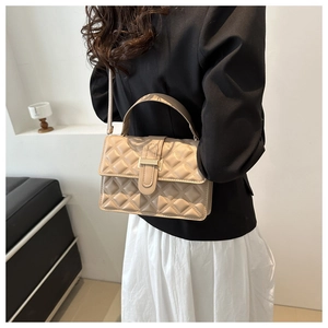 Close-up of quilted beige crossbody bag with gold metal buckle and leather strap