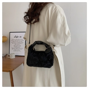 Détail du sac à main en fausse fourrure noire avec poignée froncée et maillons dorés