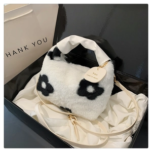 Gros plan du sac hobo en peluche avec motif floral dans un coffret cadeau noir élégant