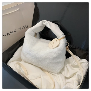 Vue détaillée du sac en fausse fourrure blanche avec chaîne dorée et anse en cuir