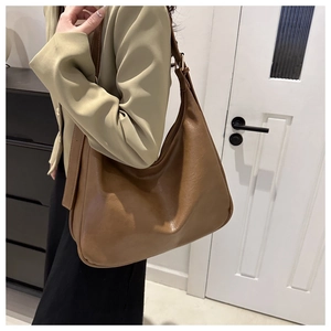 Detailansicht einer großen braunen Hobo-Tasche mit strukturiertem PU-Leder und Goldschnalle