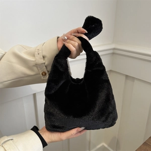 Chic black fluffy faux fur handbag styled with a beige coat for a soft winter look