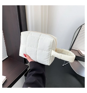 Detail of white quilted nylon handbag showing soft texture and premium stitching detail