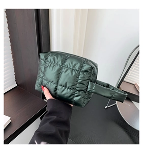 Detail of dark green quilted tote bag with glossy finish and secure zipper closure