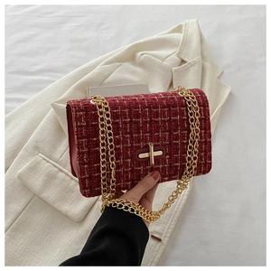 Close-up of red tweed small square bag featuring golden chain and metal turn-lock