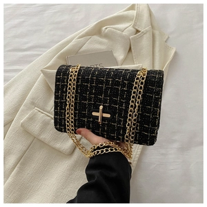 Detail of tweed crossbody bag featuring black and gold plaid texture and metal lock