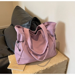 Detailed view of lavender tote bag with side drawstring adjustments and nylon texture