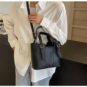 Gros plan détaillé d'un sac cabas en cuir noir avec ferrures dorées et bandoulière