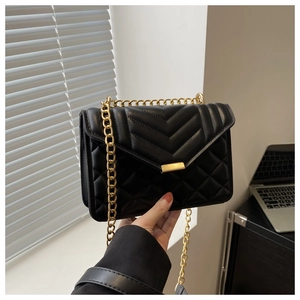 Detailed view of black quilted crossbody bag with gold chain strap and metal clasp