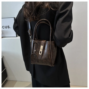 Dettaglio della borsa a secchiello vintage marrone scuro con texture opaca e fibbia