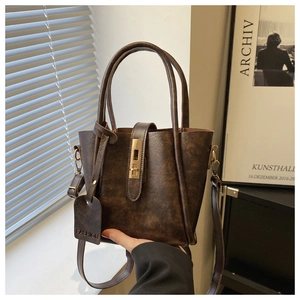 Dettaglio borsa tote in pelle vintage marrone scuro con hardware dorato e tag