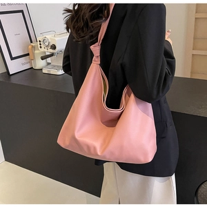 Side view of soft pink pebbled leather tote bag with stylish knotted shoulder strap detail