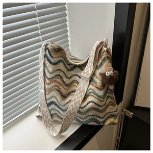 Knitted wave pattern crossbody bag with jacquard strap and plush monster charm