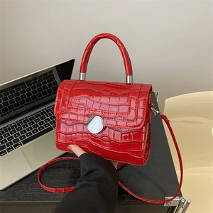 Chic red crocodile pattern handbag with top handle and silver hardware in office setting