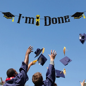 Bannière noire scintillante I'm Done avec chapeaux de diplômés sur fond de ciel bleu