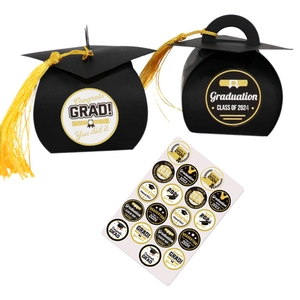 Close-up of black graduation cap gift boxes with yellow tassels and celebratory stickers