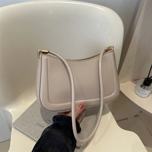 Chic beige U-shaped faux leather shoulder bag with fine stitching and gold metal hardware