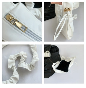 Gros plan du sac à bandoulière blanc montrant la fermeture dorée et la texture plissée