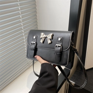 Elegant black PU leather crossbody bag with silver bow buckle and white stitching detail