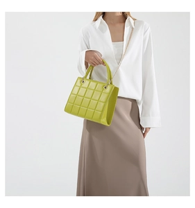 Detailed view of the vibrant green quilted crossbody bag with a gold chain strap