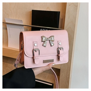 Detailed view of pink PU leather bag featuring a silver bow and belt buckle hardware