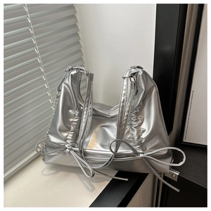 Detail of silver metallic soft leather shoulder bag with bow drawstring and chain strap