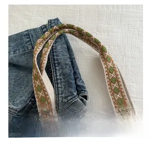 Détail de la sangle de sac en toile avec broderie ethnique et texture robuste