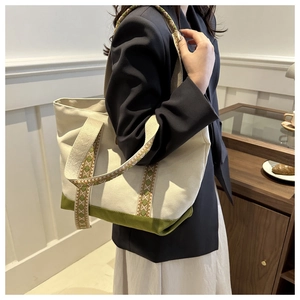 Détail du sac cabas en toile montrant le fond vert et la bandoulière tissée style ethnique