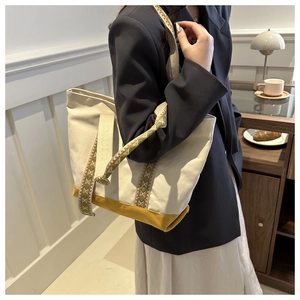Vue latérale d'un grand sac cabas en toile avec base jaune et bandoulière jacquard