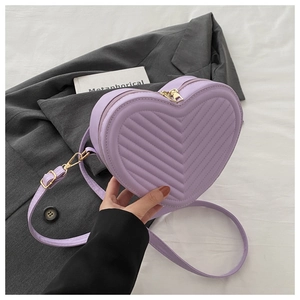 Detail of purple heart-shaped crossbody bag with V-quilted faux leather and gold hardware