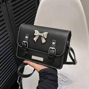 Minimalist black PU leather crossbody bag with a large silver bow and metallic buckle