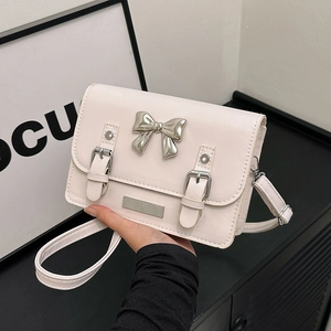 Elegant ivory rectangular crossbody bag with silver bow accent and adjustable straps