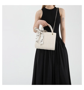 Detailansicht cremefarbene Stepptasche mit Seidentuchgriff und goldener Kette
