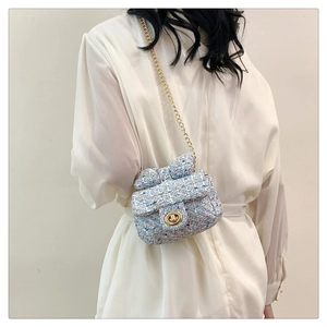 Close-up of a colorful tweed crossbody bag with a bow accent and gold metal chain strap