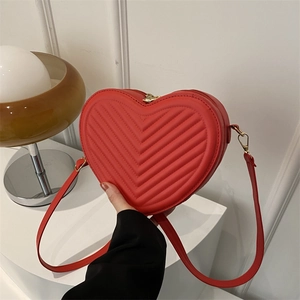 Chic red heart-shaped shoulder bag featuring elegant V-shaped quilting and gold hardware