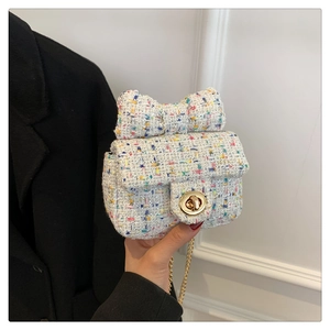 Detailed view of mini tweed crossbody bag featuring a large bow and gold swivel lock