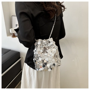 Detail of silver sequin bucket bag with drawstring closure and fine chain shoulder strap