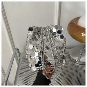Detail of silver sequin bucket bag with metal chain strap and reflective sequins