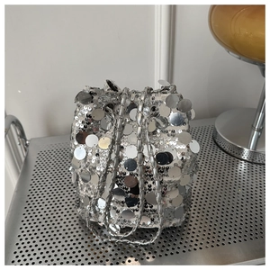 Detail of silver sequin bucket bag with metal chain strap and drawstring closure