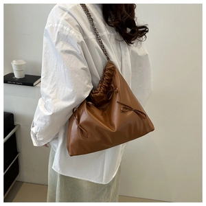 Détail du sac cabas en cuir marron avec plis et bandoulière en chaîne argentée