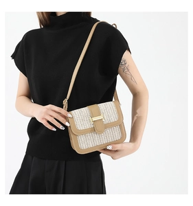 Détail du sac bandoulière tissé avec garniture en cuir kaki et boucle en métal doré en H