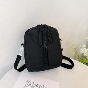 Minimalist black nylon crossbody phone bag with woven knot zippers on white background